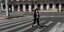 Κοπέλα περπατά σε άδειο δρόμο στην Αθήνα εν μέσω κορωνοϊού