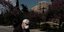 Ανδρας με μάσκα περπατά στην Δ. Αρεοπαγίτου με φόντο την Ακρόπολη