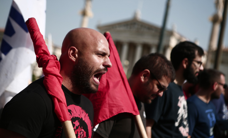 Μέλος του ΠΑΜΕ φωνάζει συνθήματα κατά τη διάρκεια της πορείας 