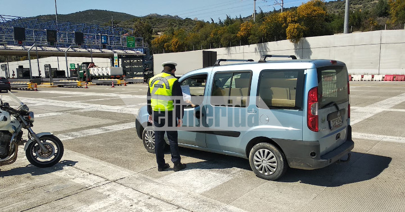 Αστυνομικός διενεργεί έλεγχο στα διόδια της Ελευσίνας λόγω των μέτρων για τον κορωνοϊό