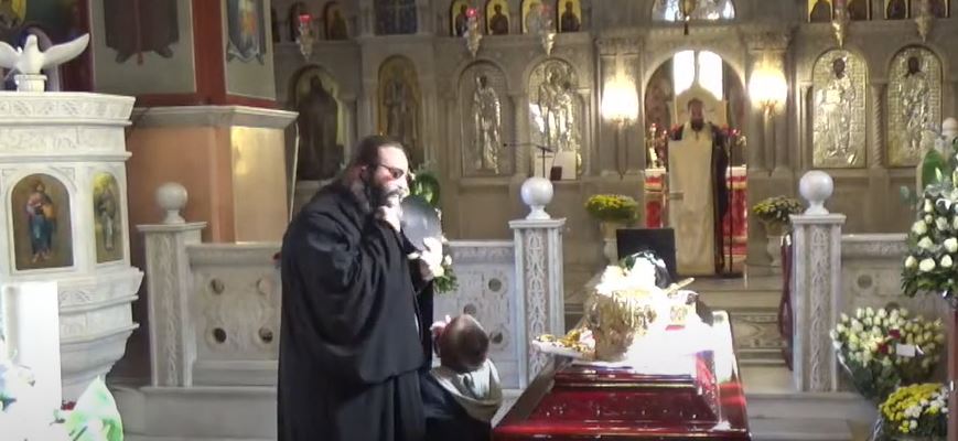 The priest took off his mask after putting the little boy on the ground