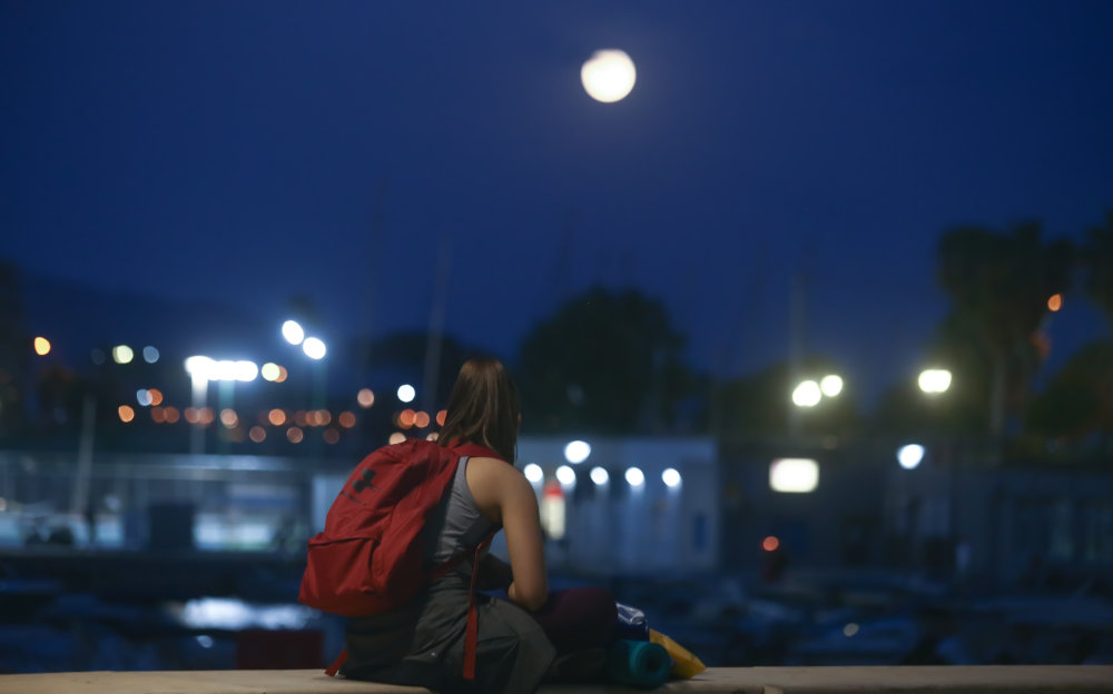 Μια κοπέλα χαζεύει το φαινόμενο της έκλειψης παρασκιάς από τον Πειραιά