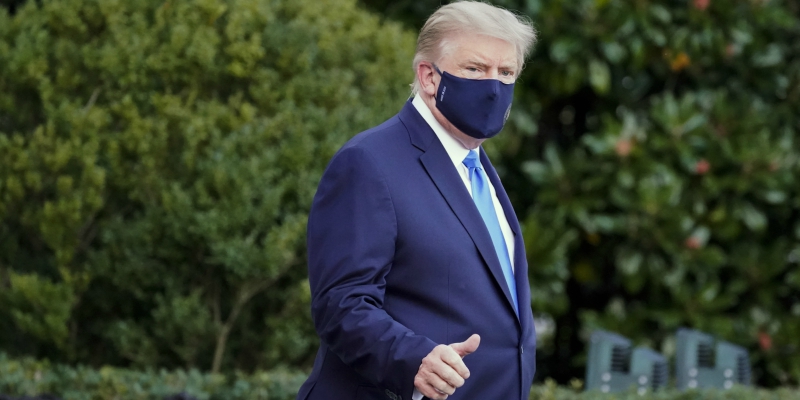 Ο Τραμπ καταβεβλημένος και με μάσκα, κατευθύνεται προς το ελικόπτερο που τον περιμένει στο προαύλιο του Λευκού Οίκου