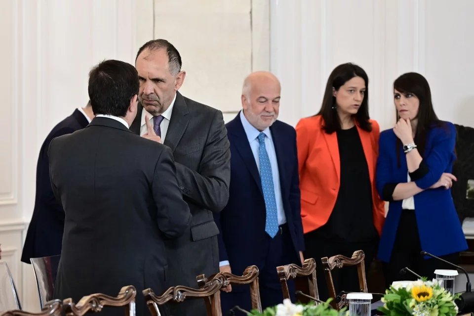 Γιώργος Γεραπετρίτης-Νότης Μηταράκης στο ένα πηγαδάκι, ο Γιώργος Φλωρίδης ενώ ψάχνει τη θέση του και οι κυρίες του ΥΠΕΣ, η υπουργός Νίκη Κεραμέως με την υφυπουργό της Βιβή Χαραλαμπογιάννη σε σύντομη συζήτηση. 