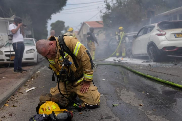 Ισραηλινός πυροσβέστης λυγίζει μετά το χτύπημα στην Ασκελόν -Φωτογραφία: AP Photo/Ohad Zwigenberg