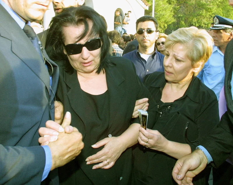 Η σύζυγος του Στέλιου Καζαντζίδη, Βάσω, υποβασταζόμενη στην κηδεία του λαϊκού τραγουδιστή 