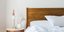 Δωμάτιο ξενοδοχείου με κρεβάτι, κομοδίνο, λευκά σεντόνια
