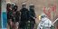 Αστυνομικοί κοιτάζουν διαδηλωτή στο Ιράκ