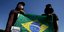 Διαδηλωτές στην Βραζιλία με σημαία της χώρας γεμάτη σταυρούς