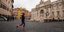 Γυναίκα τρέχει μπροστά στην άδεια πλατεία, με φόντο την Φοντάνα ντι Τρέβι στη Ρώμη