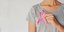 γυναίκα κρατά σύμβολο του καρκίνου του μαστού