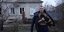 άνδρας με σκύλο έξω από σπίτι μετά τον βομβαρδισμό στην Ουκρανία