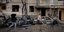 Κάτοικοι της Μαριούπολης μπροστά σε βομβαρδισμένα κτίρια 