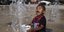 Παιδί παίζει με τα νερά συντριβανιού στην Πόλη του Μεξικό