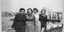 Αίγινα, κομψές κυρίες στον μώλο του Αγίου Νικολάου -Στο βάθος το κτήριο Βογιατζή
