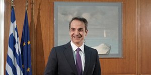Ο Κυριάκος Μητσοτάκης χαμογελαστός στο γραφείο του στη Βουλή