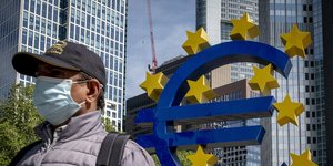 Άνδρας με μάσκα έξω από τα κεντρικά της ΕΚΤ στη Φρανκφούρτη της Γερμανίας